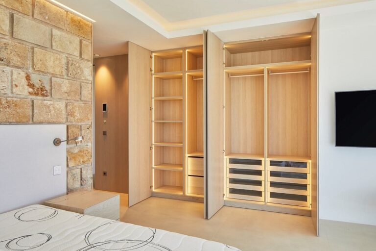 Armario empotrado a medida con iluminación LED y acabados de carpintería de lujo en dormitorio de Casa Noah en Ibiza