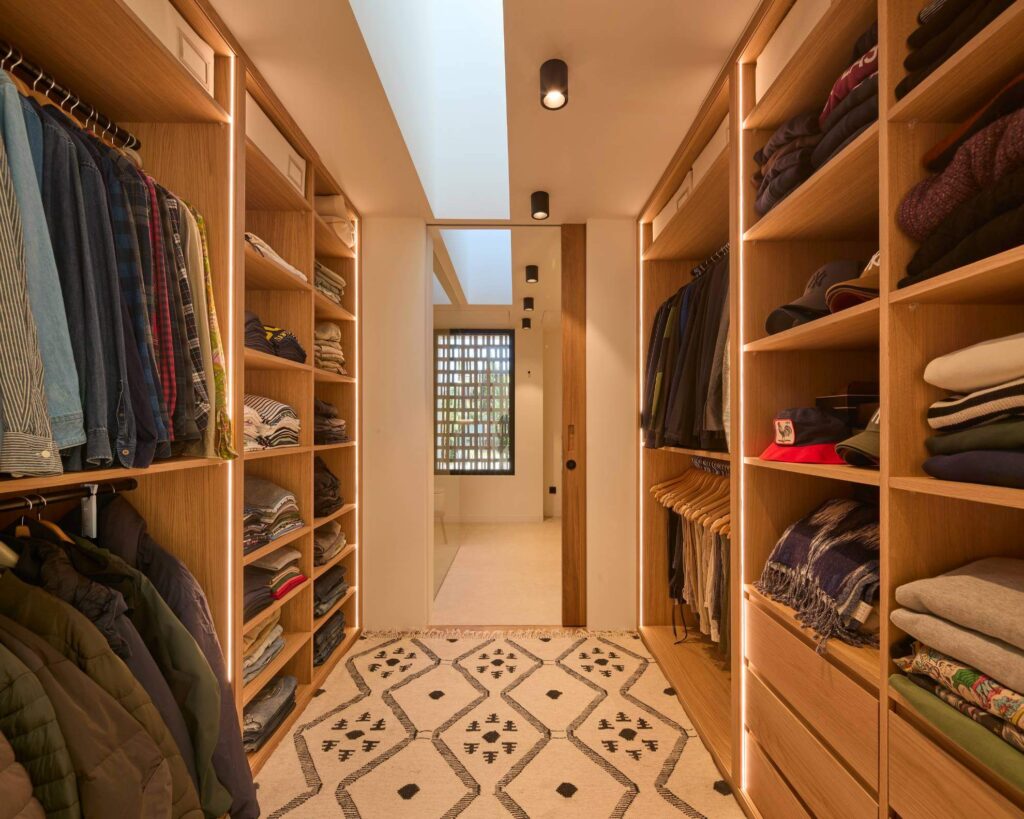 Vestidor a medida en Ibiza con iluminación LED y estanterías de madera