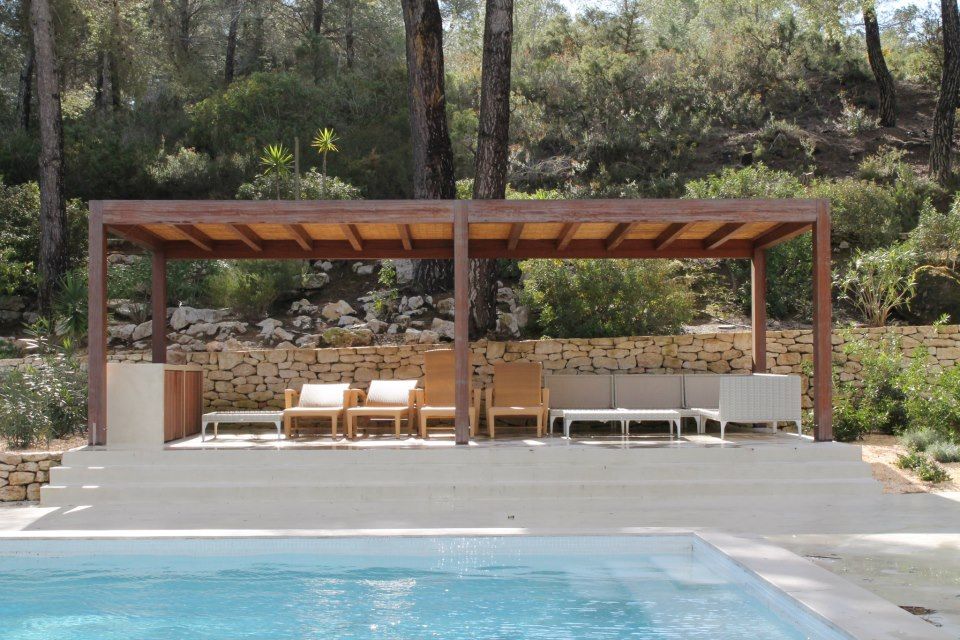 Pérgola de madera junto a piscina en Ibiza con diseño moderno y funcional