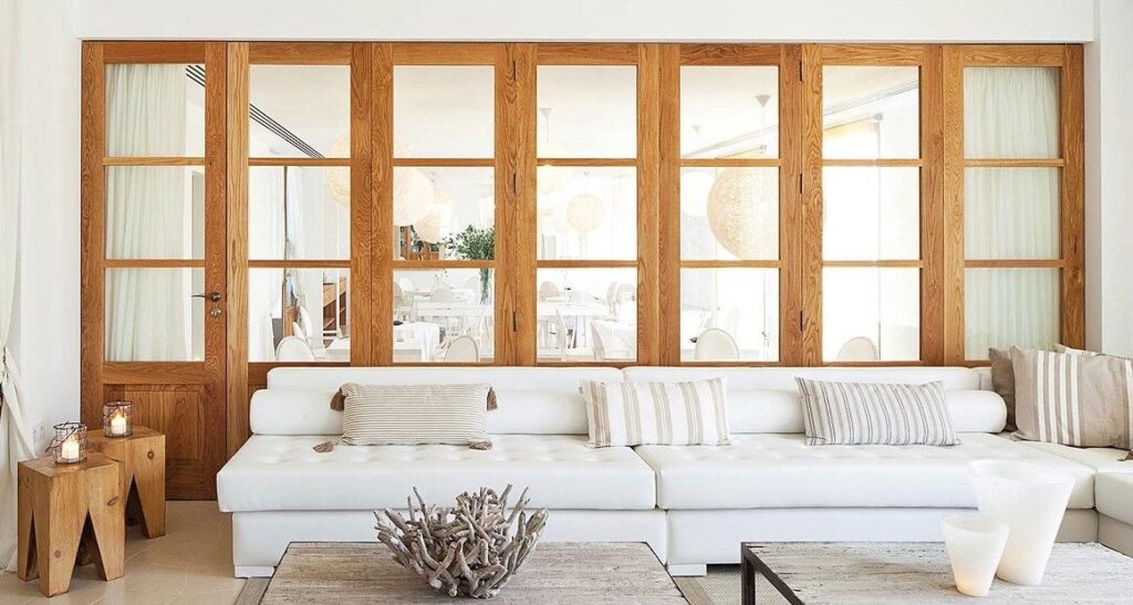 Cristaleras de madera a medida como división interior en salón de estilo mediterráneo en Ibiza