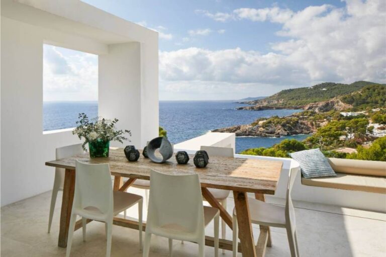 Terraza con mesa de madera natural a medida y vistas al mar en proyecto Can Corey, Ibiza