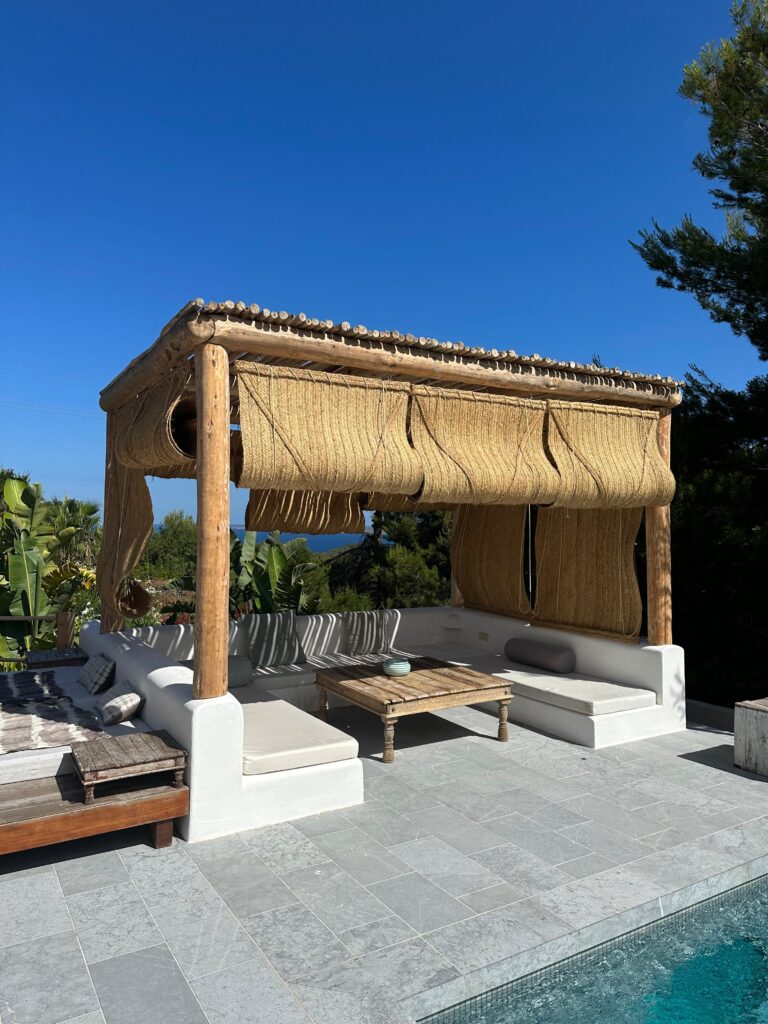 Pérgola rústica con cañizo natural junto a piscina en Ibiza